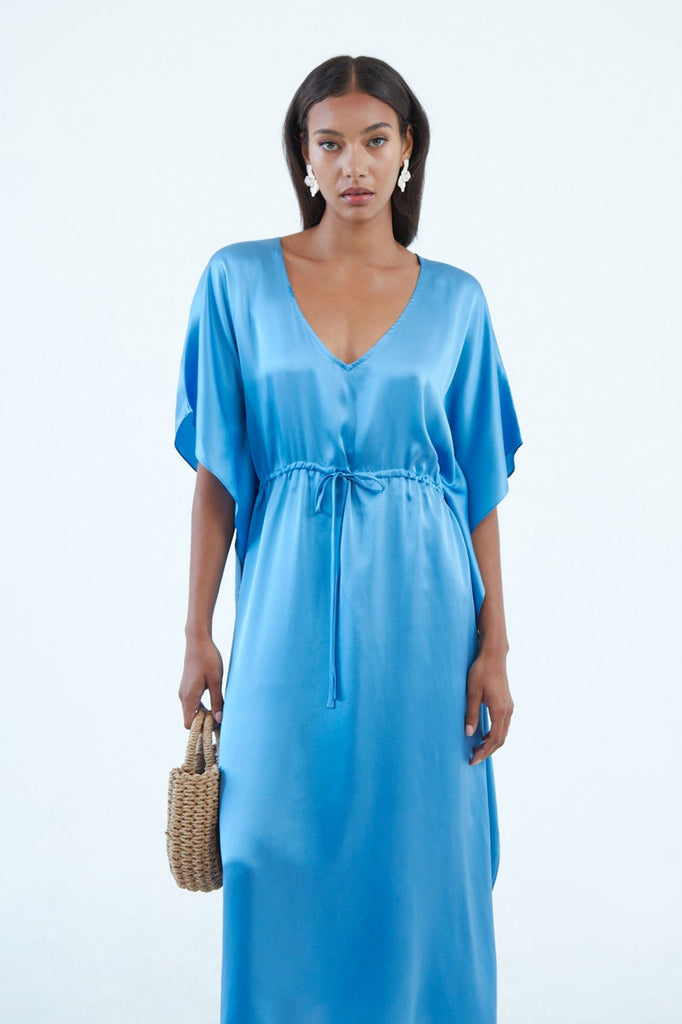 full length indigo blue silk caftan dress with low V neck, waist tie, and wide elbow-length sleeves extending to hem