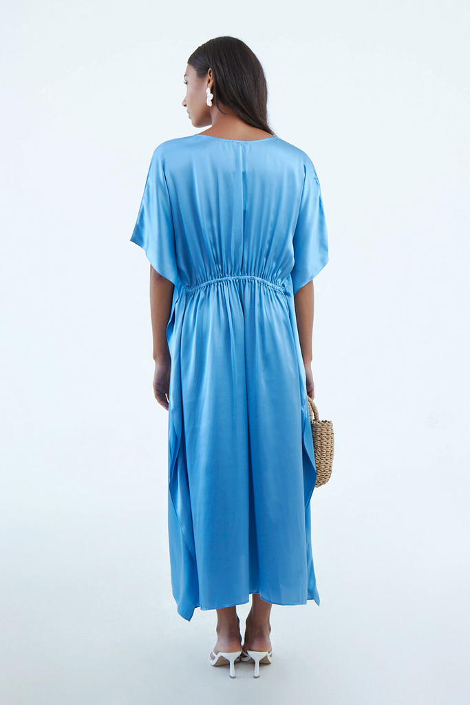 back of full blue indigo blue silk kaftan dress with elastic waist tie, and wide elbow-length sleeves, continuous to hem