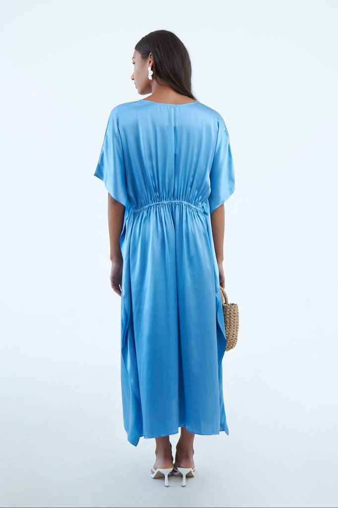 back of full blue indigo blue silk kaftan dress with elastic waist tie, and wide elbow-length sleeves, continuous to hem