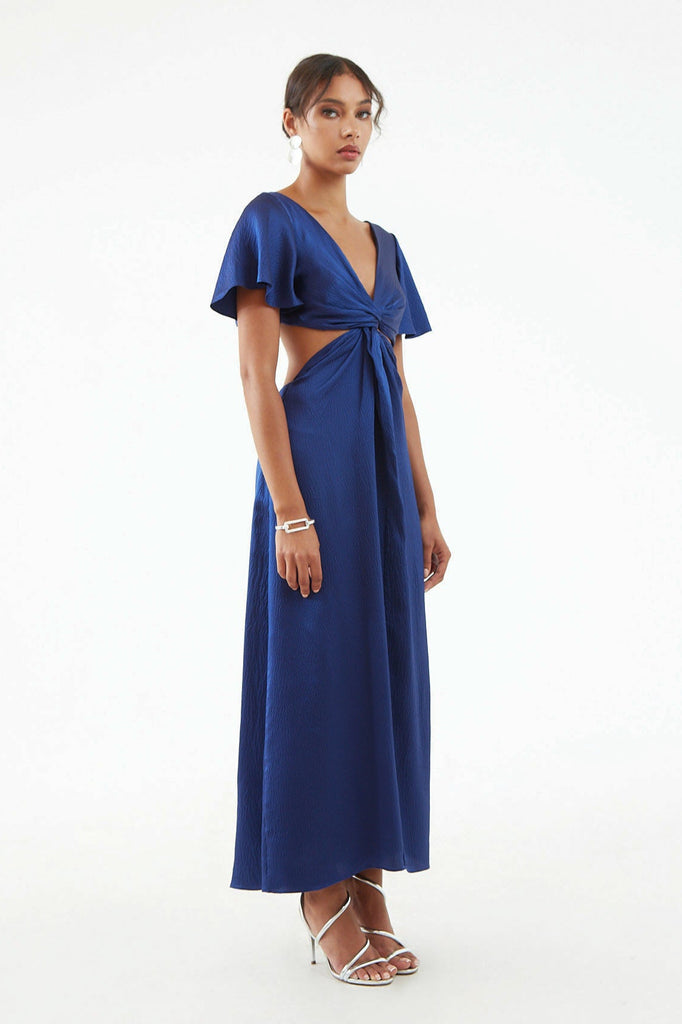 Side view of long royal blue hammered silk dress, subtle shine, front center twist with exposed waist side, flared short sleeves. 