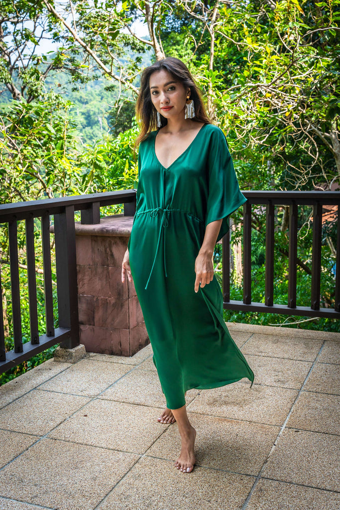 long emerald green silk kaftan dress with wide draped elbow-length sleeves, waist tie, and  low V neck