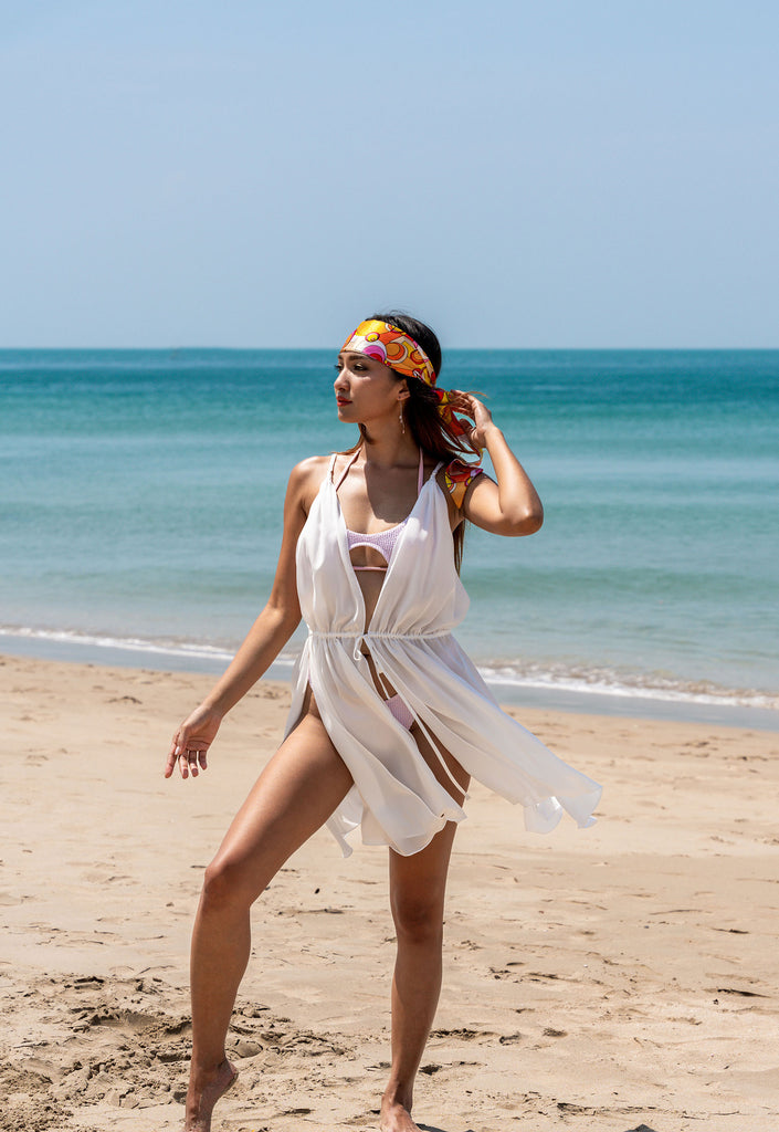 short, white, silk beach cover up dress with top to bottom slits, over swimsuit and with orange headscarf tie
