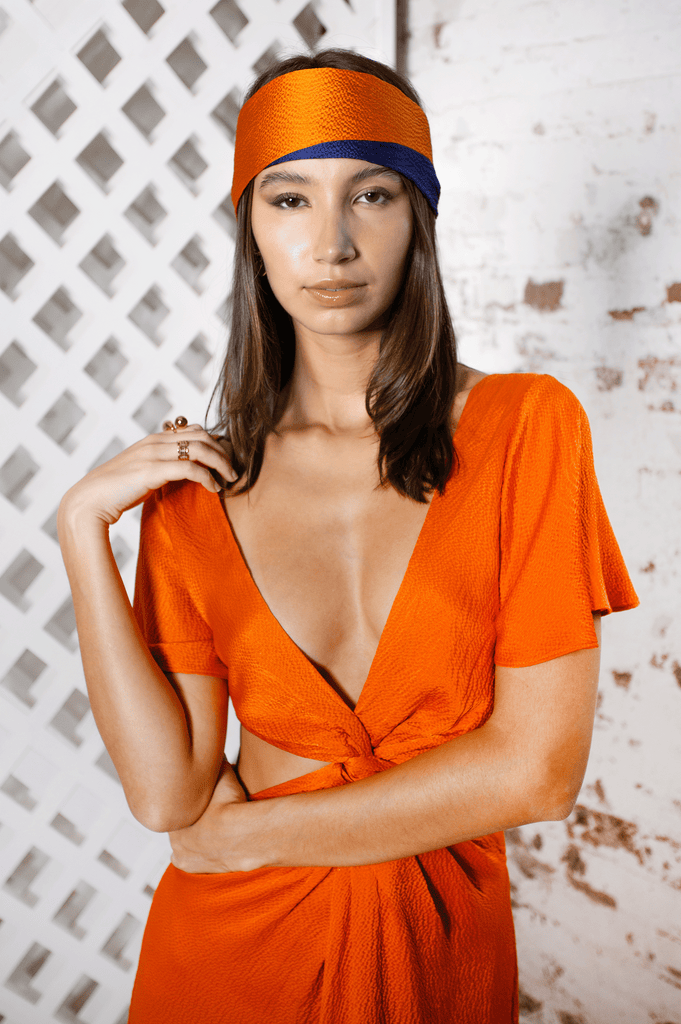 orange and blue silk headscarf with matching orange hammered silk dress with low V neck and waist cut out 