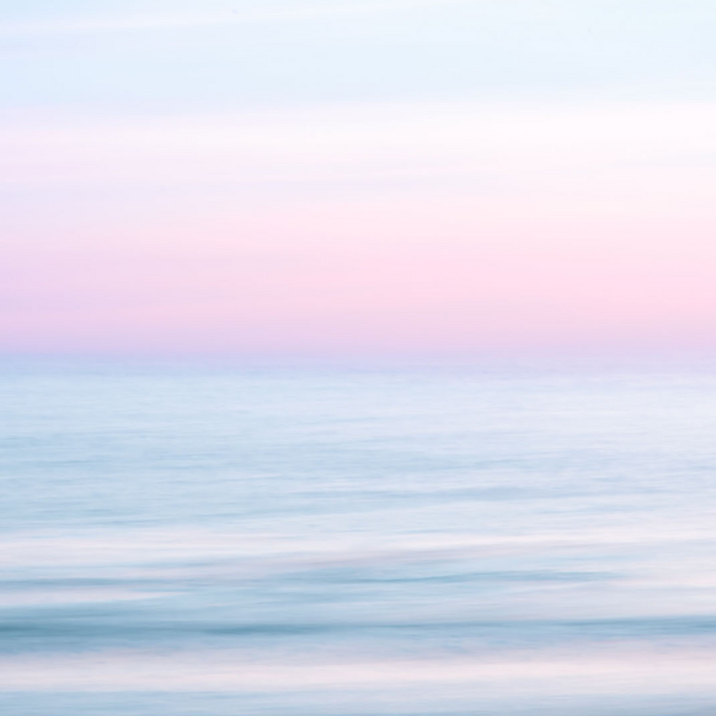 calm ocean water with purple, pink sky