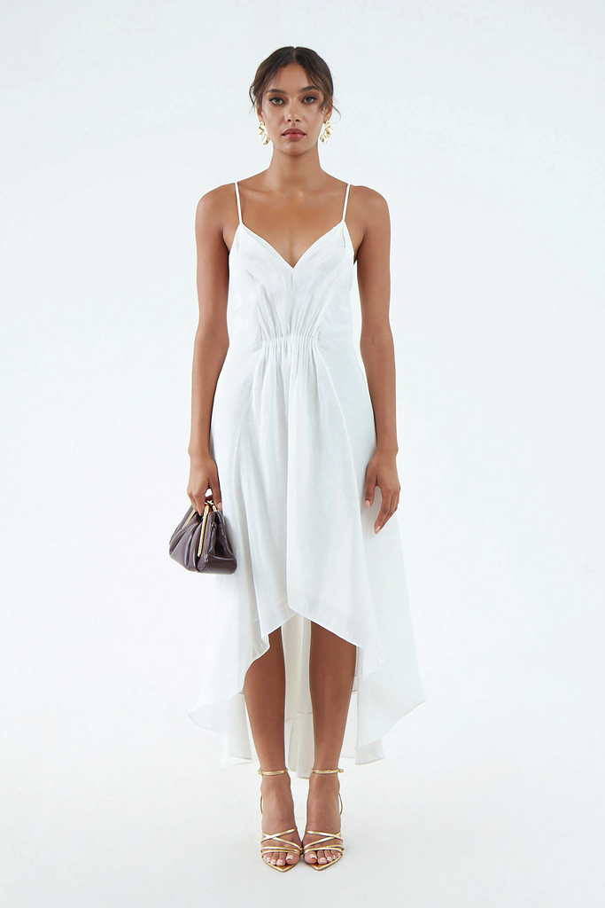 luxurious white hemp silk dress with thin shoulder straps, waist gather, flared hem that is short in front and long in back, worn with white sandals